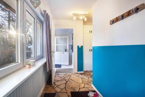 a hallway with blue and white walls and a window at Ferienhaus Sandstrand in Timmendorfer Strand