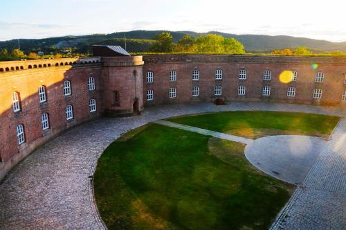 a large brick building with a green lawn in front at Oscarsborg Castle Hotel & Resort in Drøbak