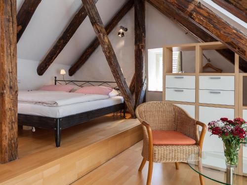 a bedroom with a bed and a chair and a glass table at Ferienwohnungen Hensler in Lindau
