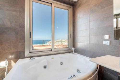 a bath tub in a bathroom with a window at Stunning Casa Bella Vista in Adeje