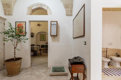 a hallway with a toilet and a potted plant at Antica corte dell'800 in Castrignano del Capo