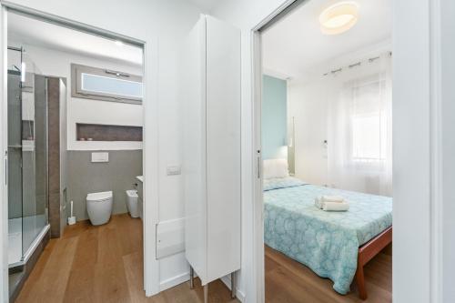a small bedroom with a bed and a bathroom at 4 Seasons Apartment in Guspini