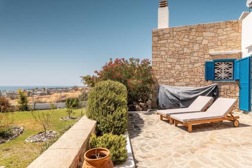 a patio with a bench and a stone wall at Villa Kalliope in Gennadi