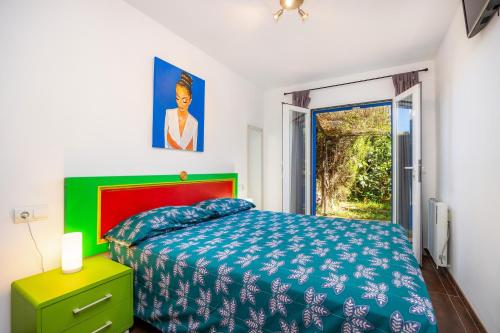 a bedroom with a bed with a blue and green bedspread at Casa Arts 50 in Campos