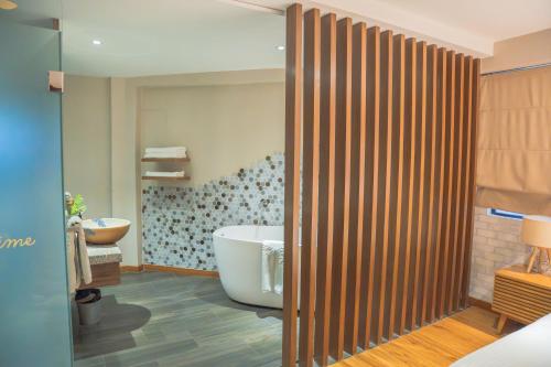 a bathroom with a bath tub and a sink at Sojourn Spa Hotel Kuala Lumpur in Kuala Lumpur