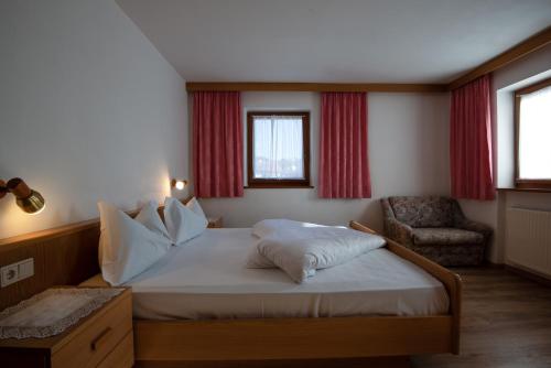 a small bedroom with a bed and a chair at Apartment 1 - Zur Sonne in Laion