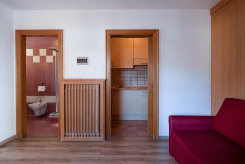 a living room with a red couch and a kitchen at Apartment 1 - Zur Sonne in Laion