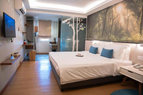 a bedroom with a large bed with a large painting on the wall at Sojourn Spa Hotel Kuala Lumpur in Kuala Lumpur
