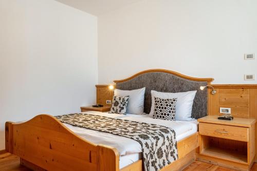 a bedroom with a bed with a wooden headboard at Schreiberhof Panorama in Laion