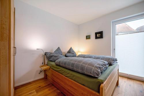 a bedroom with a bed with pillows and a window at Ferienwohnung an der Gustavsburg in Homburg