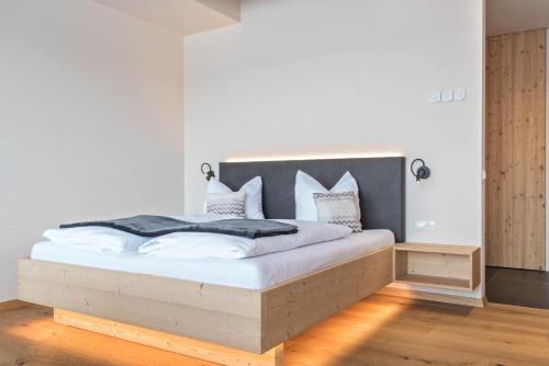 a bedroom with a large bed with white sheets and pillows at Aura Chalets - Nr 1 in Castelrotto