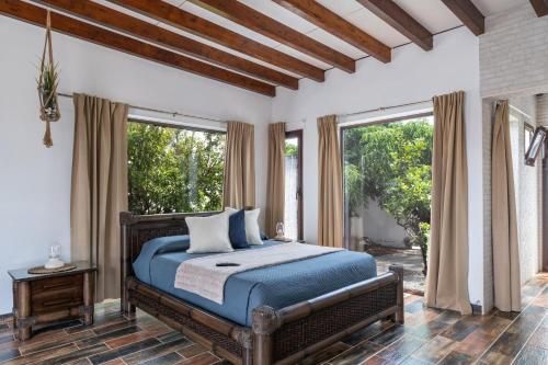 a bedroom with a bed with blue sheets and windows at Guenia ll in El Mojón