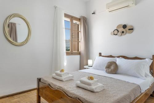 a white bedroom with two towels on a bed at Peter's Paradise in Telendos