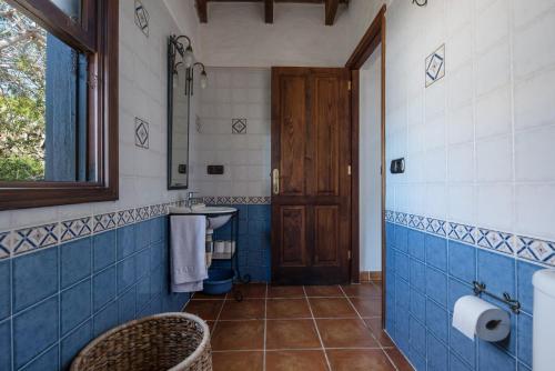 a bathroom with a toilet and a sink and blue tiles at La Cuadra de Arona in Arona