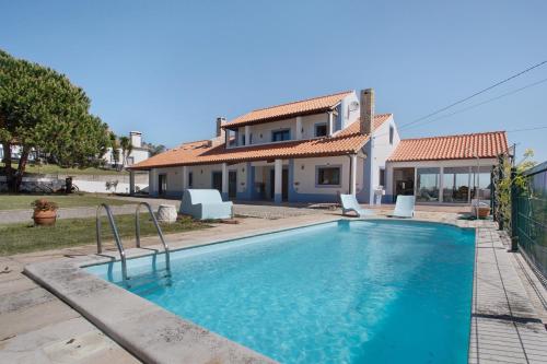 a villa with a swimming pool in front of a house at Melquites Country House in Barrantes