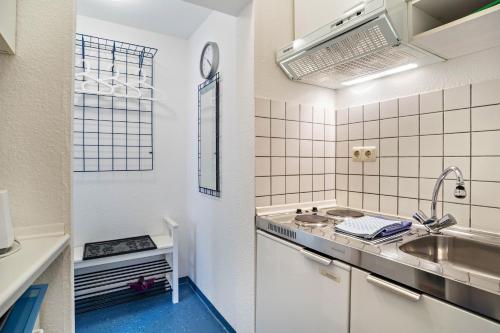 a white kitchen with a sink and a counter at Nordhaus Ferienwohnung 6 in Cuxhaven
