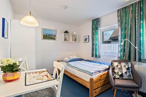a small bedroom with a bed and a desk and a table at Nordhaus Ferienwohnung 6 in Cuxhaven