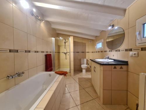 a bathroom with a tub and a toilet and a sink at Casa tranquila torrox in Cómpeta