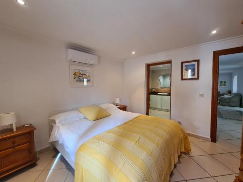 a bedroom with a bed with a yellow blanket on it at Casa tranquila torrox in Cómpeta