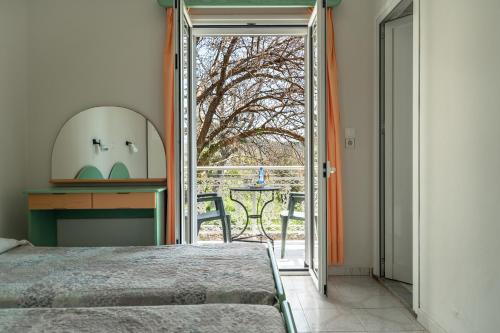a bedroom with a bed and a door to a patio at Angela partial sea view 5 in Kefallonia