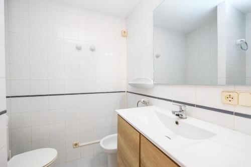 a white bathroom with a sink and a toilet at Can Vidal Cabrera in Ses Salines