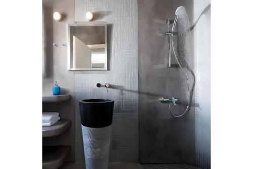 a bathroom with a shower with a glass door at Echinousa Kimolos katoikia no6 in Kimolos