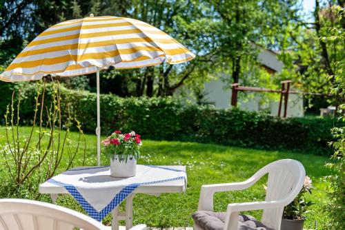 a table with a yellow and white umbrella and chairs at Ferienwohnung Zizi in Stockach