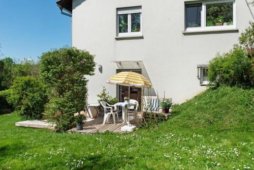 a house with a deck with a table and an umbrella at Ferienwohnung Zizi in Stockach