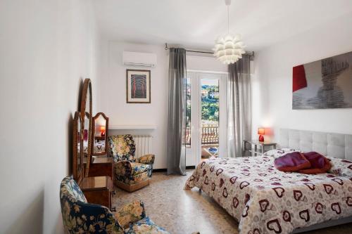 a bedroom with a bed and a chair and a window at Alassio Mare E Non Solo 2 in Alassio
