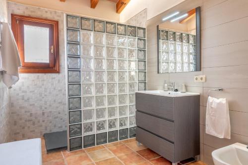 a bathroom with a sink and a glass wall at Can Siurell in Artá