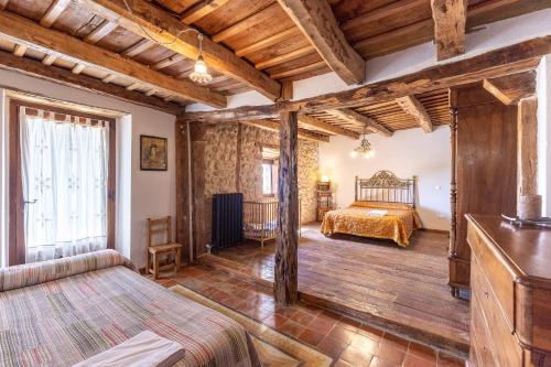 a bedroom with a bed in a room with wooden ceilings at La Botica De Maderuelo in Maderuelo