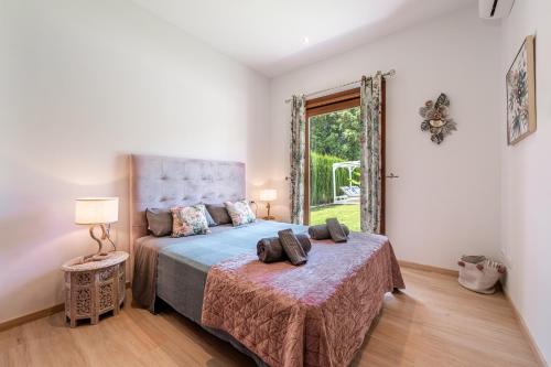 a bedroom with a bed and a large window at Villa Sa Olivera in Crestatx