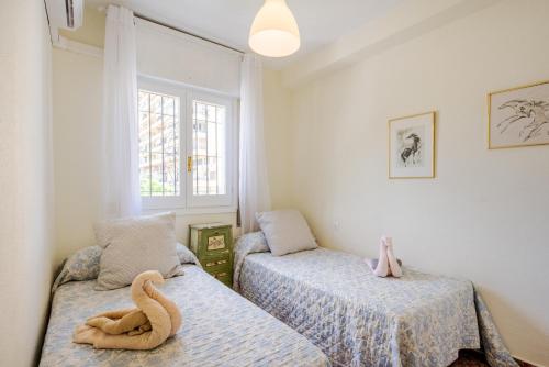 a bedroom with two beds and a window at Casa Beramendi in Torremolinos