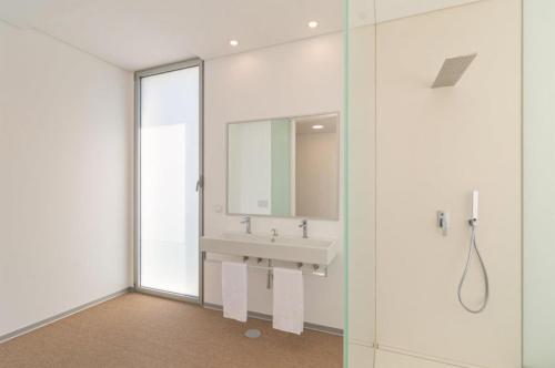 a bathroom with a sink and a mirror at Villa Camacho - Ultra Luxury in Calheta