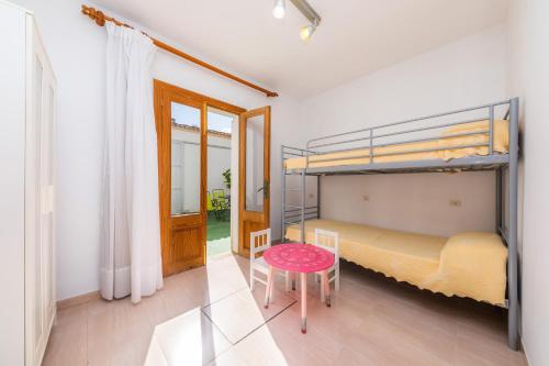 a bedroom with two bunk beds and a table at Can Miquel in Can Picafort