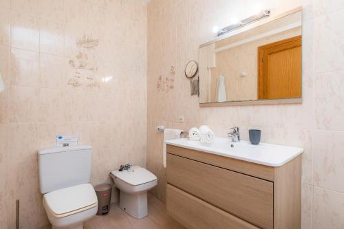a bathroom with a toilet and a sink and a mirror at Can Miquel in Can Picafort