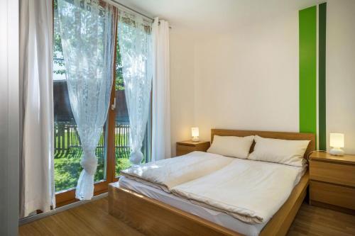 a bedroom with a bed and a large window at Ferienhaus Am Heidenbach in Deggenhausertal