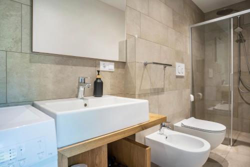 a bathroom with a white sink and a toilet at Julia's Guesthouse in Auer