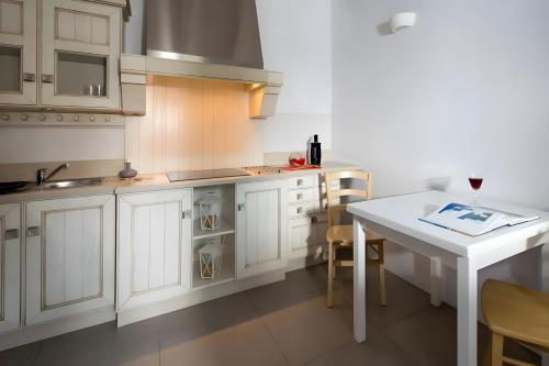 a kitchen with white cabinets and a white table at Echinousa Kimolos Maisonette no1 in Kimolos