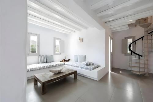 a white living room with a couch and a table at Echinousa Kimolos Maisonette no1 in Kimolos