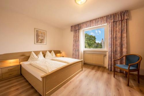 a bedroom with a bed and a window and a chair at Residence Kronstein - Fewo 2 in Tesimo