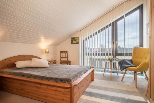 a bedroom with a bed and a large window at Schwippl in Meckenbeuren