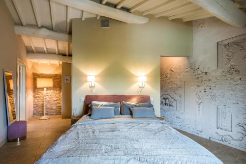 a large bedroom with a large bed with blue pillows at Brotes Appartamento Mandorlo in Sovicille