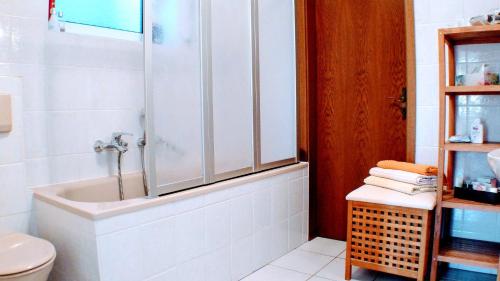 a white bathroom with a tub and a toilet at Solveigs Ferienwohnung in Bad Münstereifel