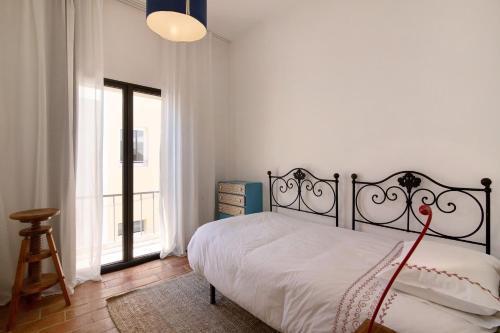 a bedroom with a bed and a large window at Casa Loulé in Loulé