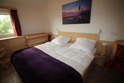 a bedroom with a large bed with white sheets at Ferienhaus Nixe7 in Dorum Neufeld