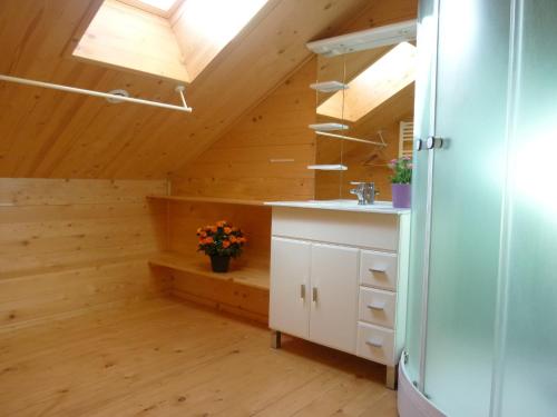 a kitchen with wooden walls and a vaulted ceiling at Deux grands chalets communicants in Les Orres