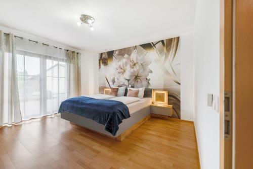 a bedroom with a bed with a flower mural on the wall at Fewo Lora in Blankenrath