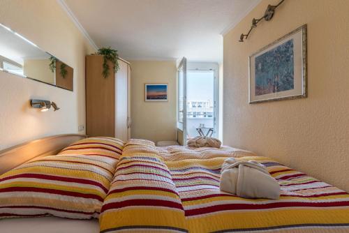 a bed with a colorful blanket on it in a room at Sylter Residenz Westerland in Westerland