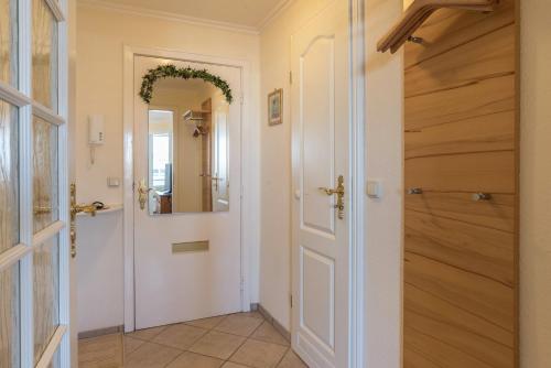 a hallway with a white door and a mirror at Sylter Residenz Westerland in Westerland